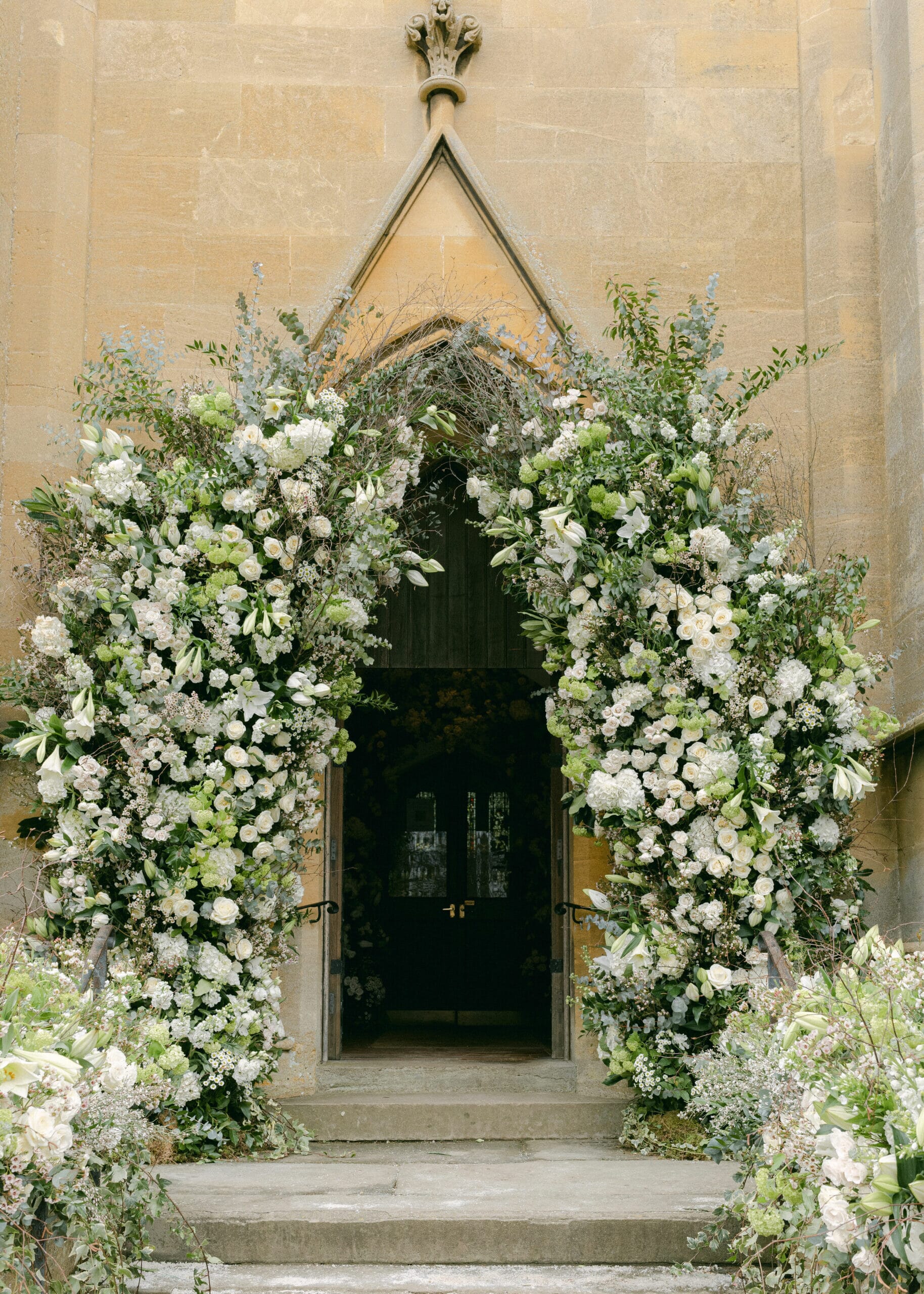 A flower filled entrance from Henry Bonas, luxury wedding planners in the UK