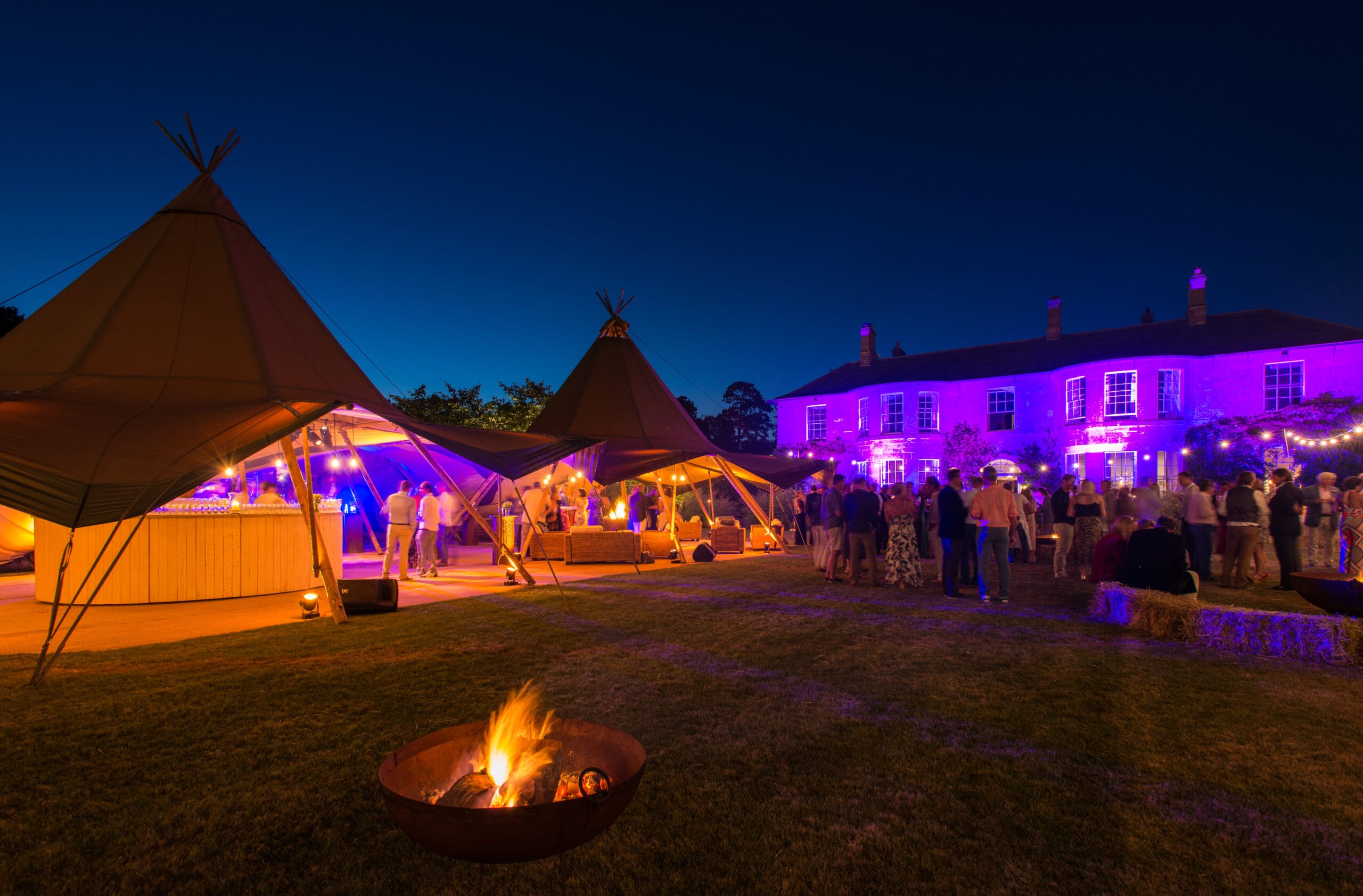 Luxury outdoor birthday party with tipi tents and fire pit