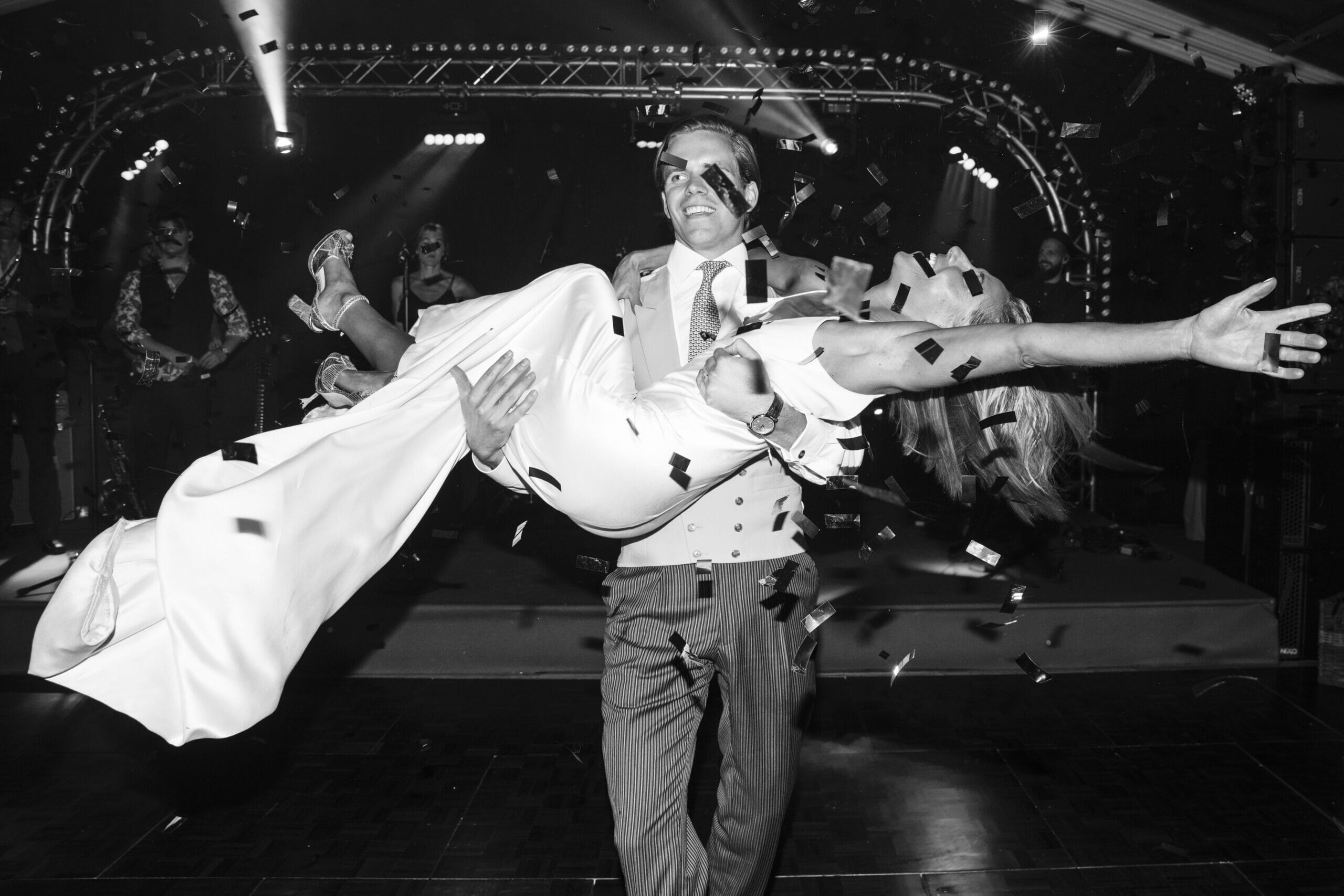 Groom lifting bride in joy at a winter wedding.