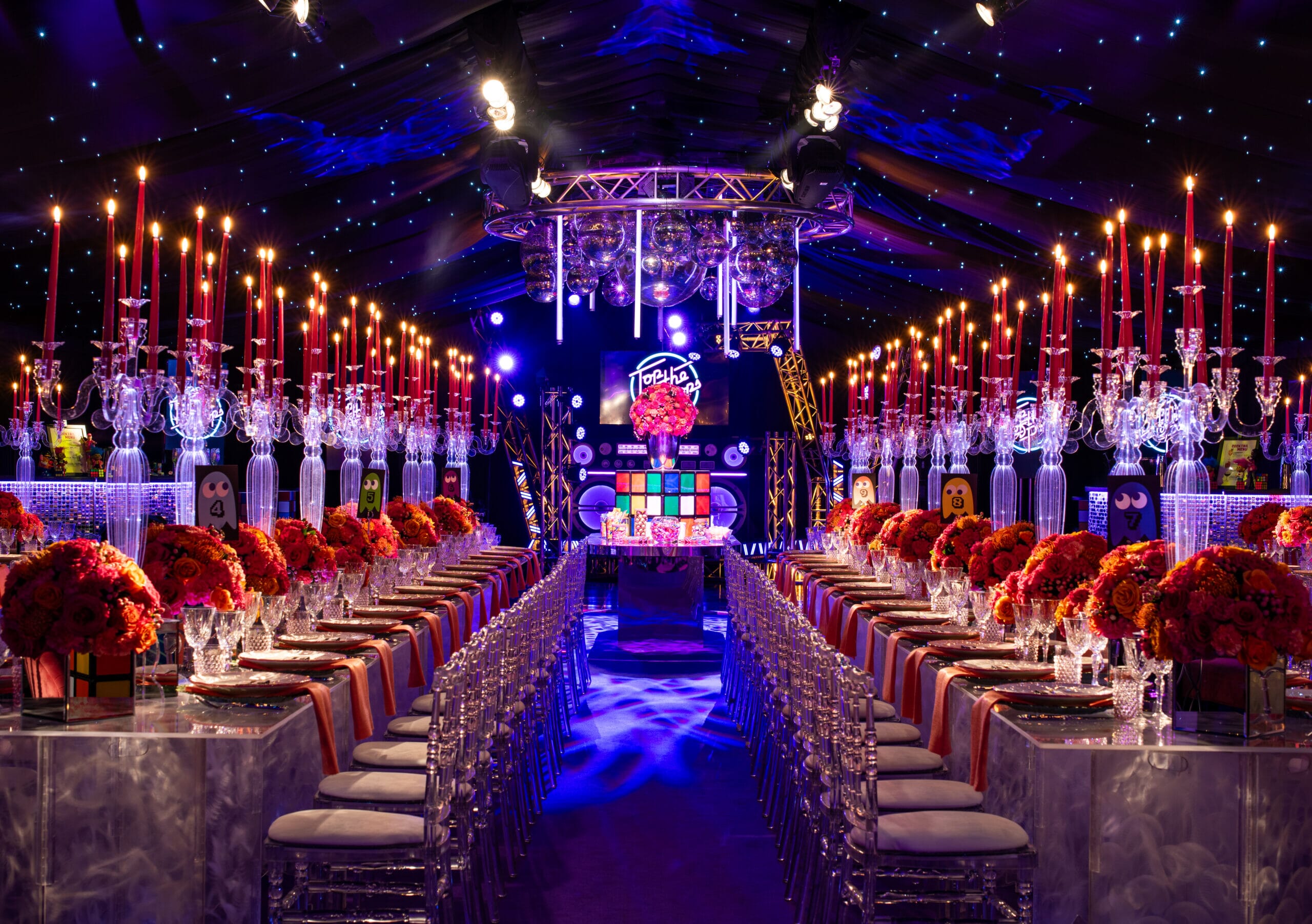 Rows of tables set for dinner at an 80s themed party