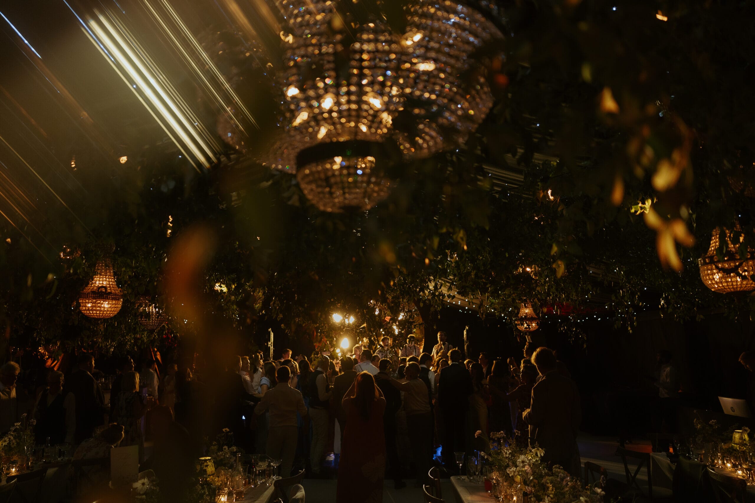 Wedding guests dancing in a beautifully lit marquee